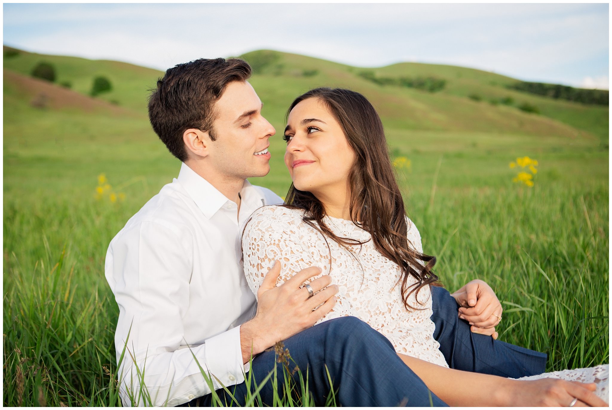 Couple laying down in tall grass for pictures