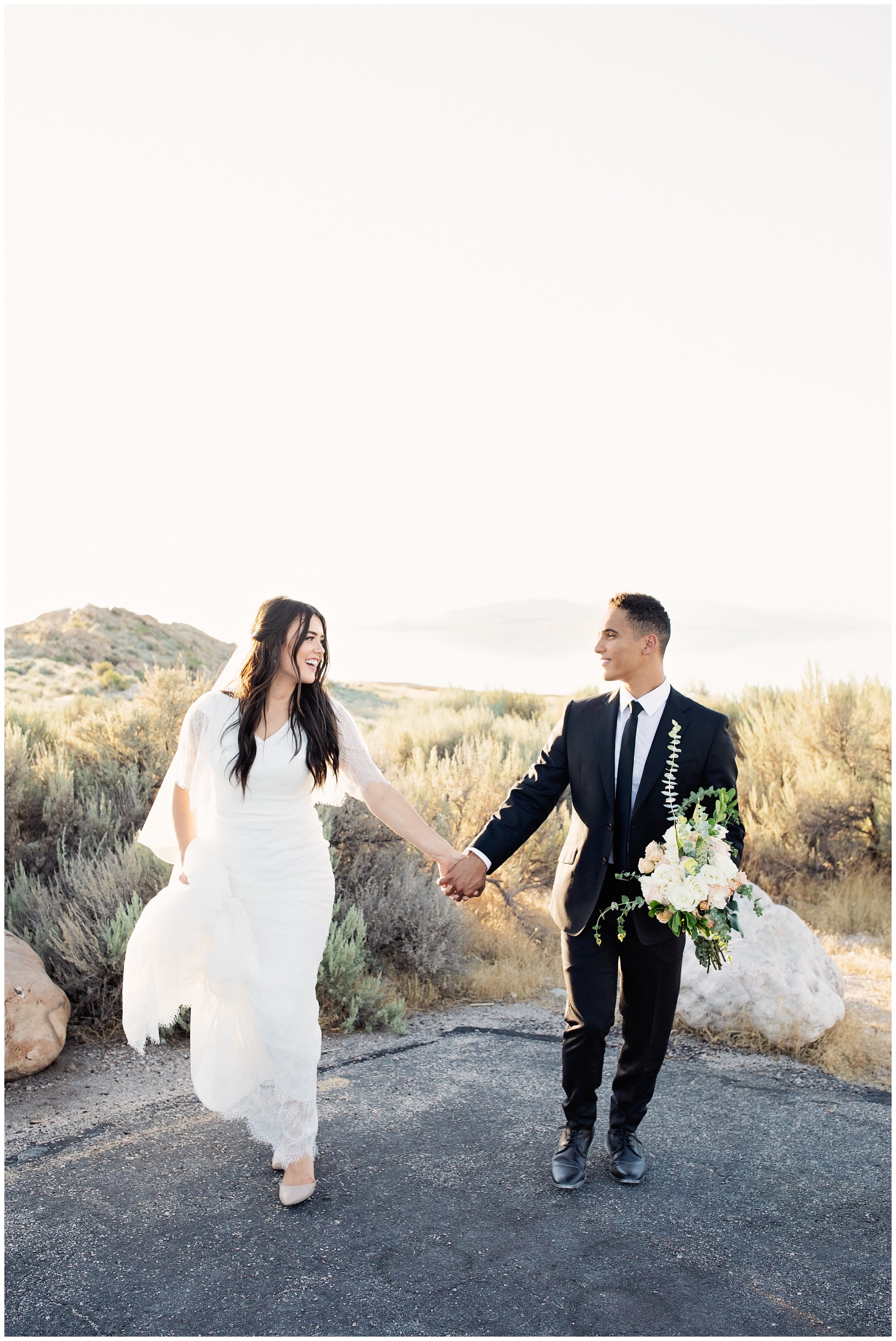 Bride and Groom running towards wedding photographer at Antelope Island