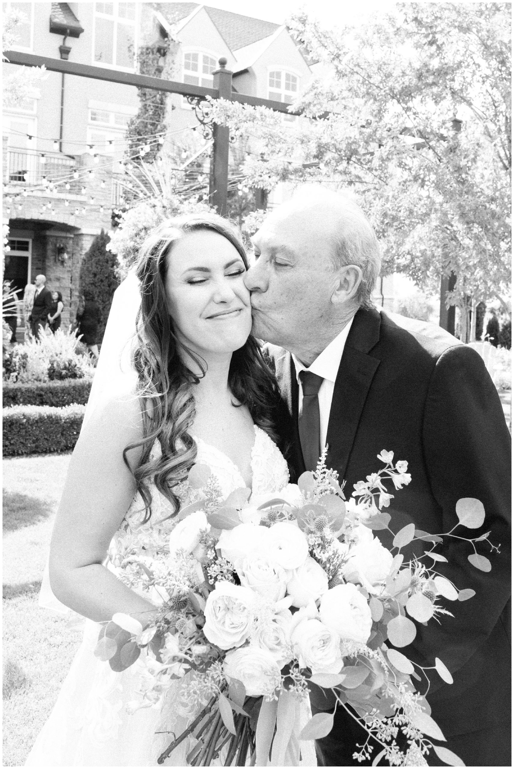 Bride and her dad kissing her cheek