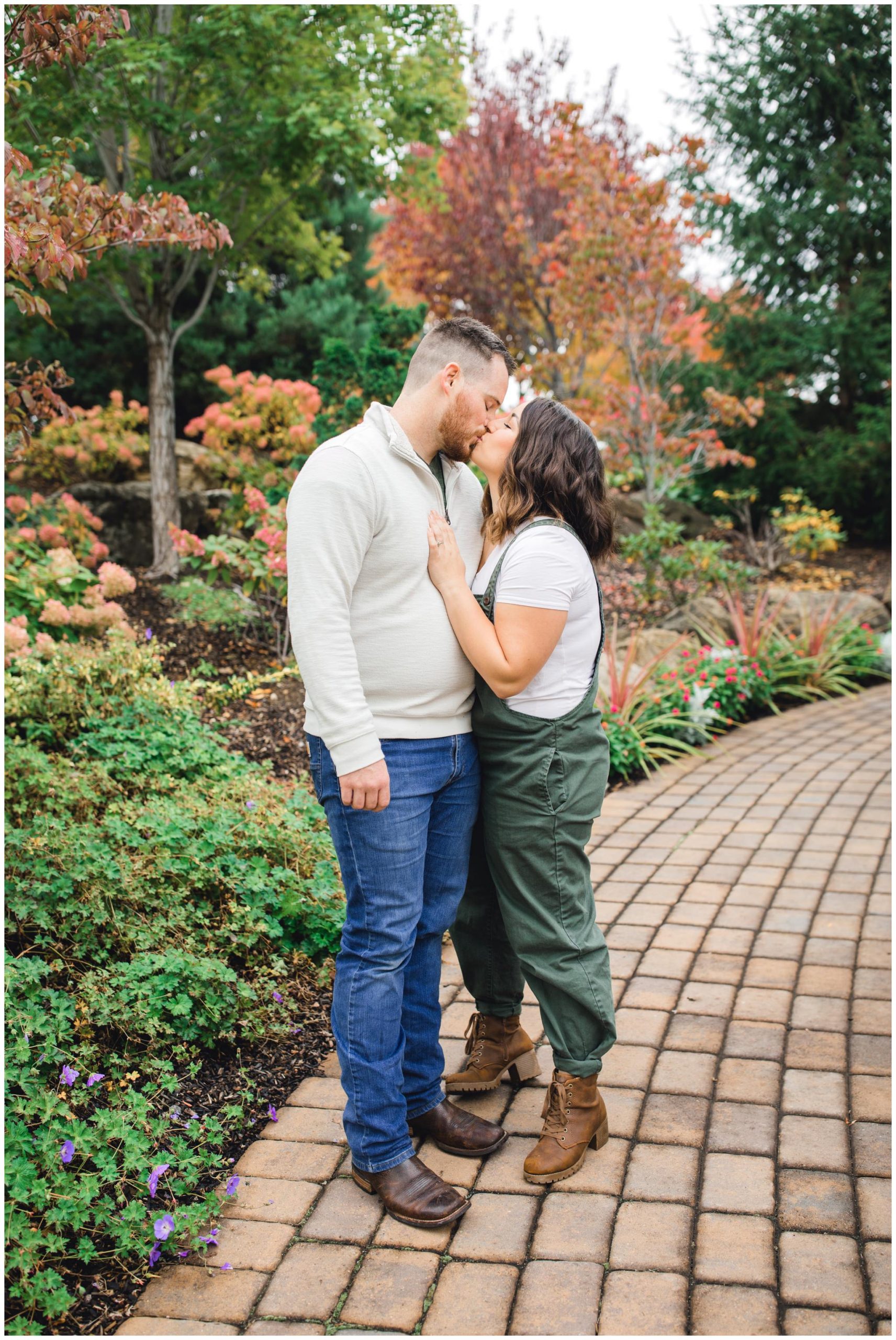 Mom and dad kissing near fall leaves