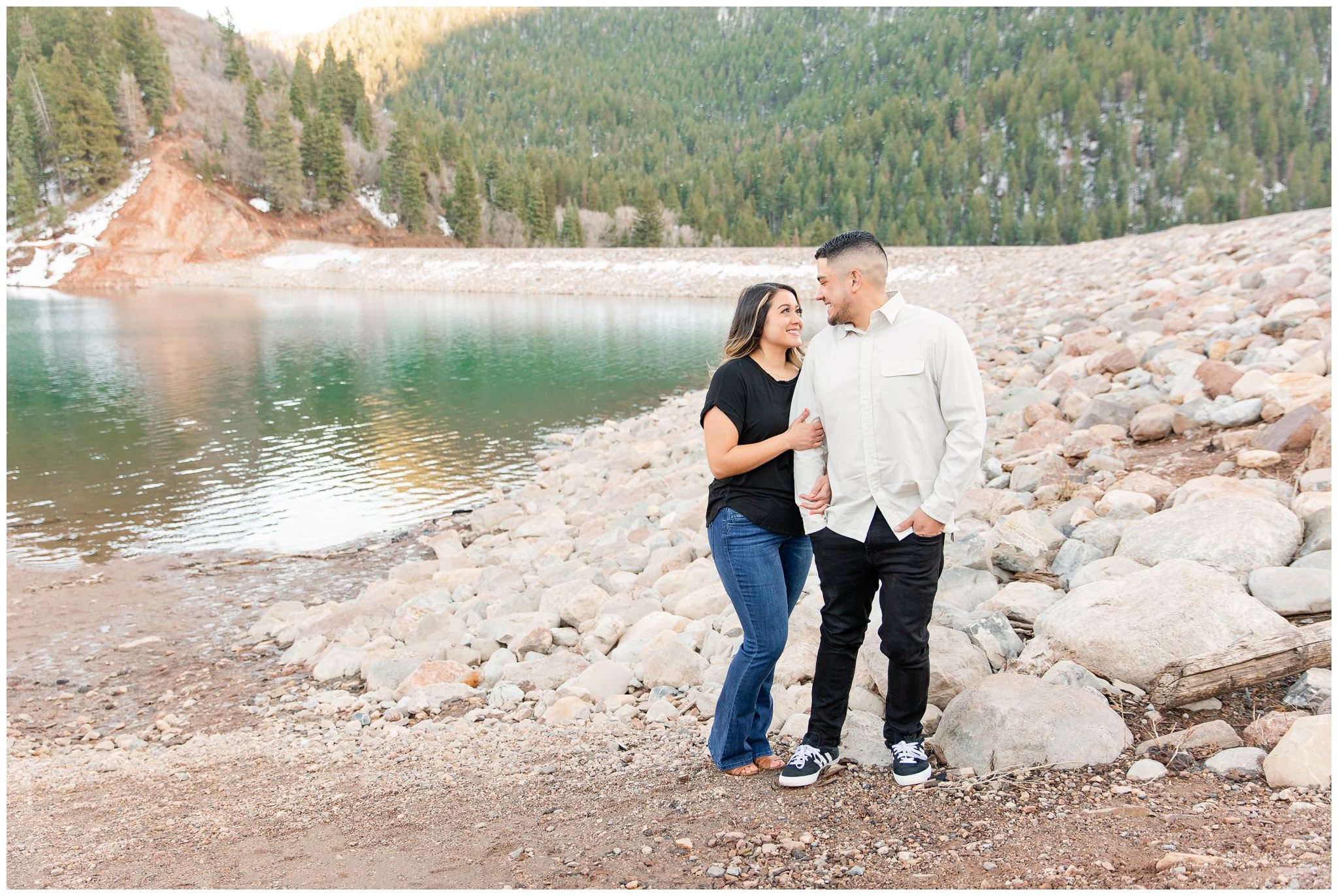 Couple posing near a blue lake in the mountains of Utah